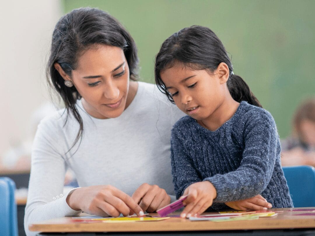 Single subject credential female elementary school teacher with young female student